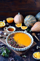 Pumpkin tart on a dark wooden background, still life