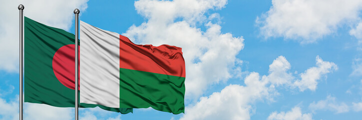 Bangladesh and Madagascar flag waving in the wind against white cloudy blue sky together. Diplomacy concept, international relations.