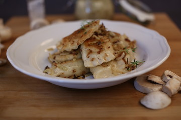 Dumplings with mushrooms. Fried home-made dumplings stuffed with mushrooms. Composition of dishes on a dark background.