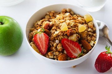 Health food. Muesli with milk, strawberry and the baked apple. High key. Close up. Selective focus.