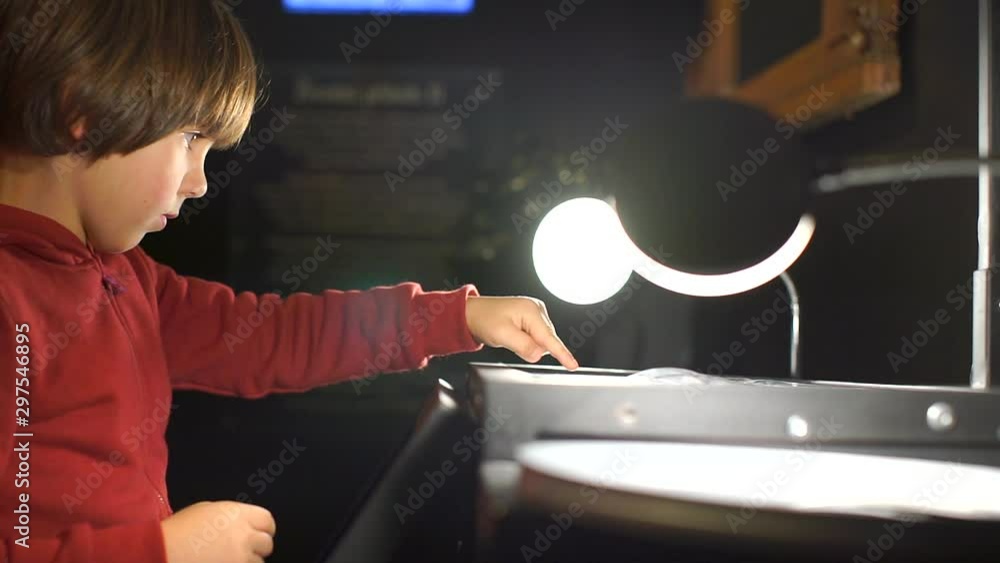 Poster the boy sitting at the table clicks on the touch buttons on the table