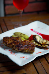 beafsteak served with fried vegetables and red wine