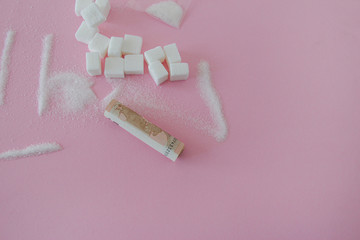 Scene recreating drugs with white sugar on pink background