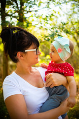 Fototapeta premium One year old baby girl hold by mother in nature