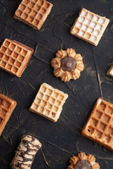 flat lay image of the wafer on the dark table, pattern cookies,
