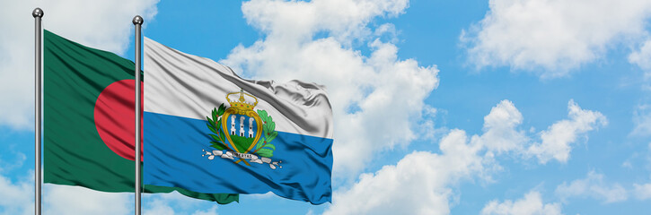 Bangladesh and San Marino flag waving in the wind against white cloudy blue sky together. Diplomacy...