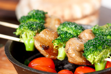 Vegan kebabs with seitan and broccoli on wooden skewers.