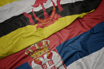 waving colorful flag of serbia and national flag of brunei.
