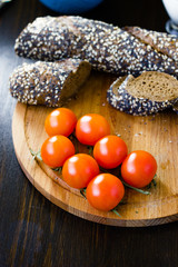 Hip of cherry tomatoes over the wooden board.