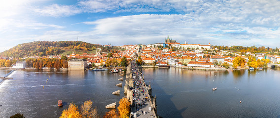 Weites Panorama von Prag im Herbst entlang der Moldau mit der Karslbrücke, dem Schloss und der...