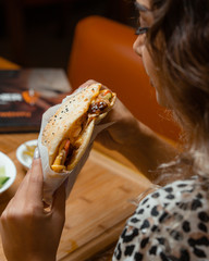 beautiful woman is trying to eat doner