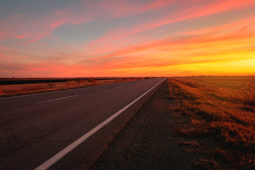 Naklejka premium sunset road on a background of colorful sky