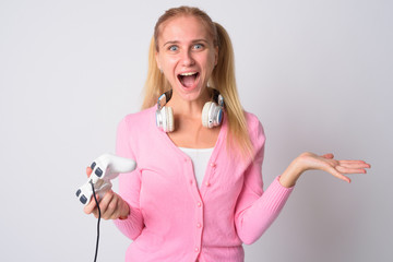 Portrait of happy young blonde nerd woman playing games and looking surprised