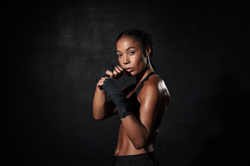 Fototapeta na wymiar Image of strong african american woman boxing in hand wraps