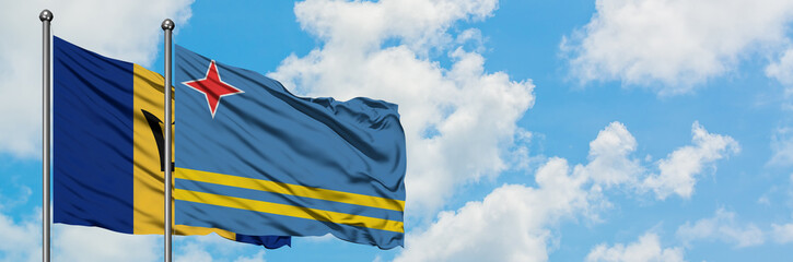 Barbados and Aruba flag waving in the wind against white cloudy blue sky together. Diplomacy concept, international relations.