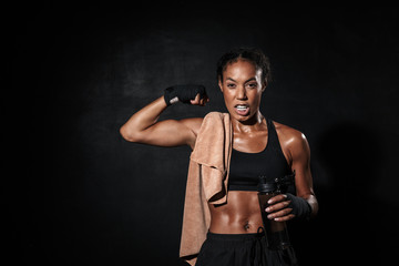 Image of african american woman in boxing hand wraps showing her bicep