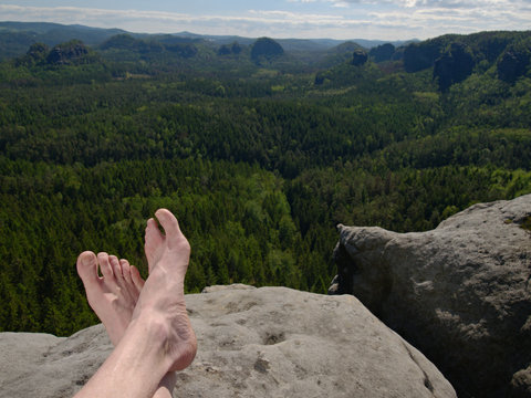 Bare feet and legs with visible veins of tourist hiker resting