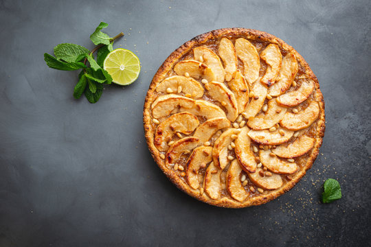 Homemade delicious fresh baked rustic apple pie on dark background, top view
