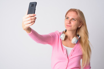 Portrait of young beautiful blonde woman taking selfie