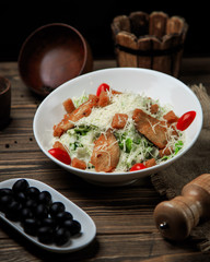 top view of mixed vegetable and meat salad served with black olive