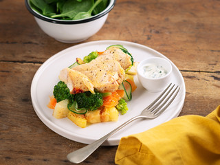 Healthy lunch, dinner. Healthy baked chicken breast with vegetables, grilled potatoes, cucumber, carrot, broccoli and spinach on a plate in a rustic style. Copy space. Proper nutrition. Dietary menu.