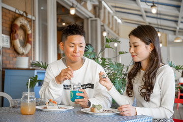 陽の当たる広場で遠くを見つめるカップル