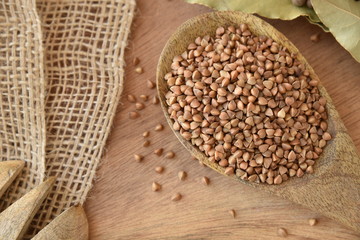Wooden spoon of roasted buckwheat. gluten free ancient grain for healthy diet, selective focus