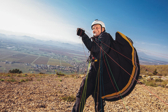 Senior paraglider on the ground prepairs to fly.