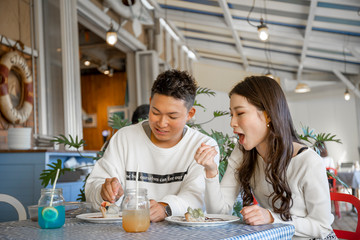 陽の当たる広場で遠くを見つめるカップル