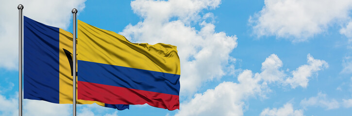 Barbados and Colombia flag waving in the wind against white cloudy blue sky together. Diplomacy concept, international relations.