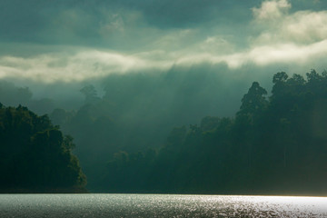 Mountain and morning mist and beautiful shadows in the Cheow Lan dam Khao Sok National Park, Thailand