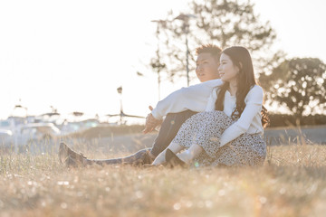 陽の当たる広場で遠くを見つめるカップル