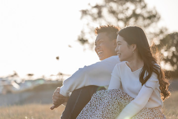 陽の当たる広場で遠くを見つめるカップル