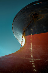 Ship's bow with red waterline against the blue sky. World shipping freight concept