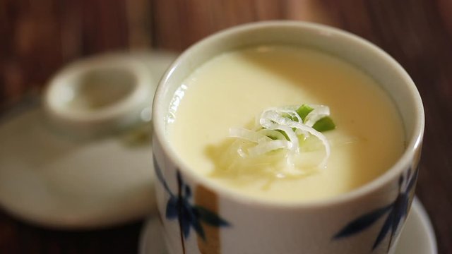 Japanese food: Chawanmushi or Steamed egg, served with onion and Japanese cooked rice on table. Clean food concept.