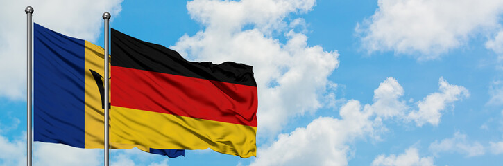 Barbados and Germany flag waving in the wind against white cloudy blue sky together. Diplomacy concept, international relations.