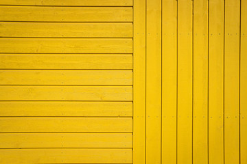 Yellow wooden texture background. Wall surface. Horizontal and vertical wooden boards. Close up with copy space