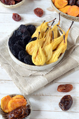 Dried pears and prunes on a white vane background