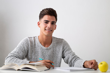 smiling teenager studying on a desk