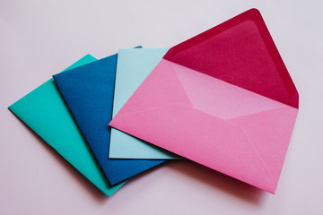 Colored paper envelopes on a light background. New mail, write message. Send and receive letter. Postal delivery service. Blank envelope, empty space. People communication, paperwork. Envelope closeup