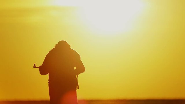 warrior with Kalashnikov at sunset day. fighter is training with a machine gun at sunset.