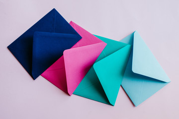 Colored paper envelopes on a light background. New mail, write message. Send and receive letter. Postal delivery service. Blank envelope, empty space. People communication, paperwork. Envelope closeup