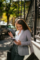 Fototapeta premium Young woman listens music on the street 