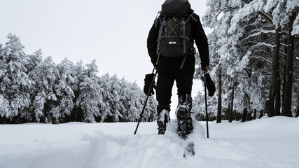 Hombre practicando raquetas de nieve en la sierra de Somosierra en Madrid