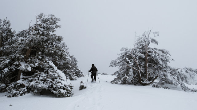 Hombre practicando raquetas de nieve en un día nublado en la sierra de Madrid