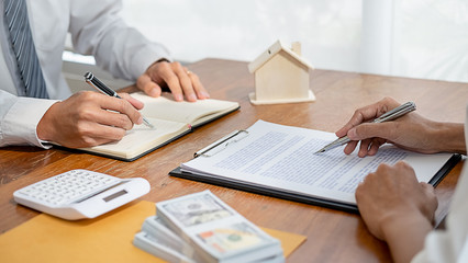 Real estate agent and customer signing contract to buy house, insurance or loan real estate.