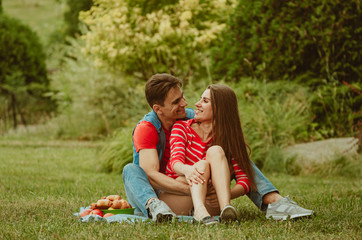 Beautiful young couple in love decided to have a romantic picnic in the park. A date, time spent together is priceless. Camping in the countryside.