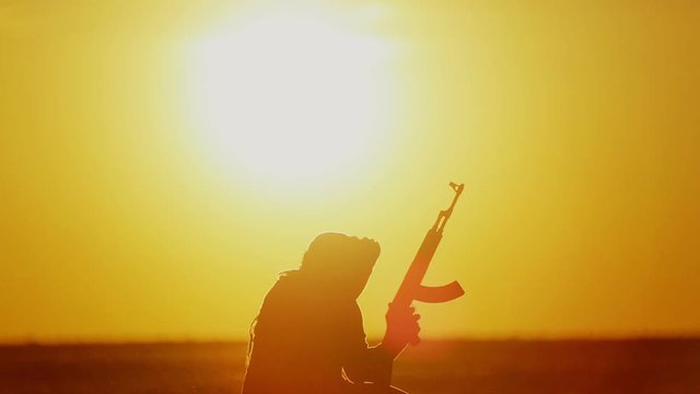 warrior with Kalashnikov at sunset day. fighter is training with a machine gun at sunset.