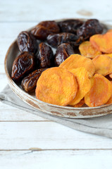 Fototapeta premium Dried dates and dried apricots on a white wooden background