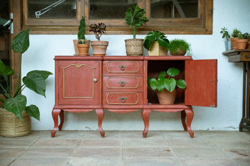 Aparador vintage / mueble antiguo con plantas en patio exterior con ventana